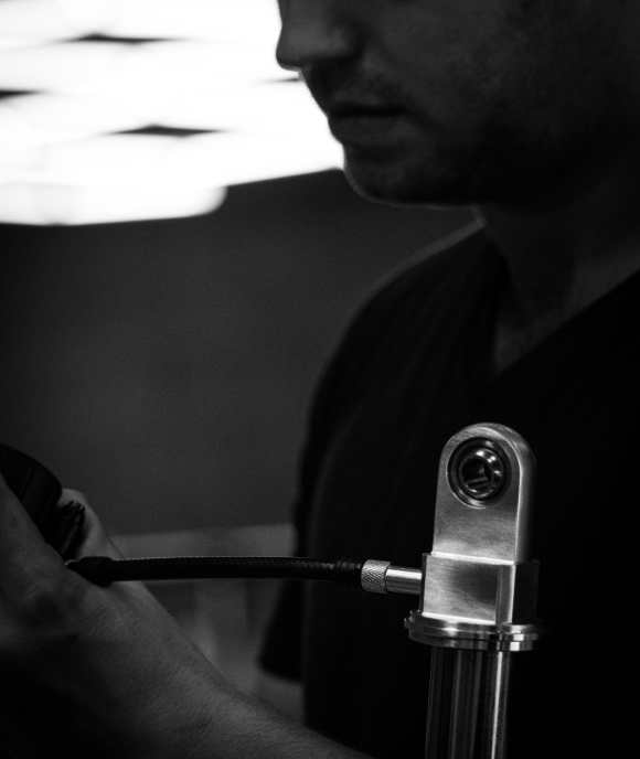 Nimbus technician assembling an oleo-pneumatic suspension unit with braided hose