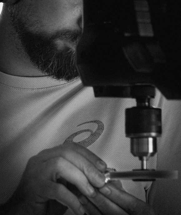 Worker at drill press performing precision operations on Nimbus component