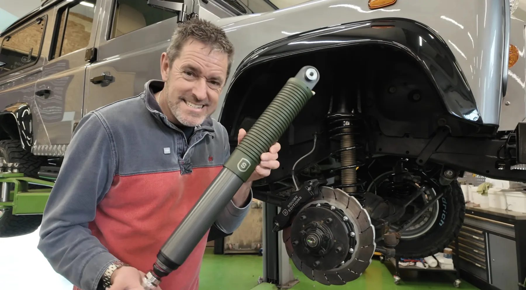 Squire Editions workshop with a Defender on a lift and a Nimbus Erebus damper being presented