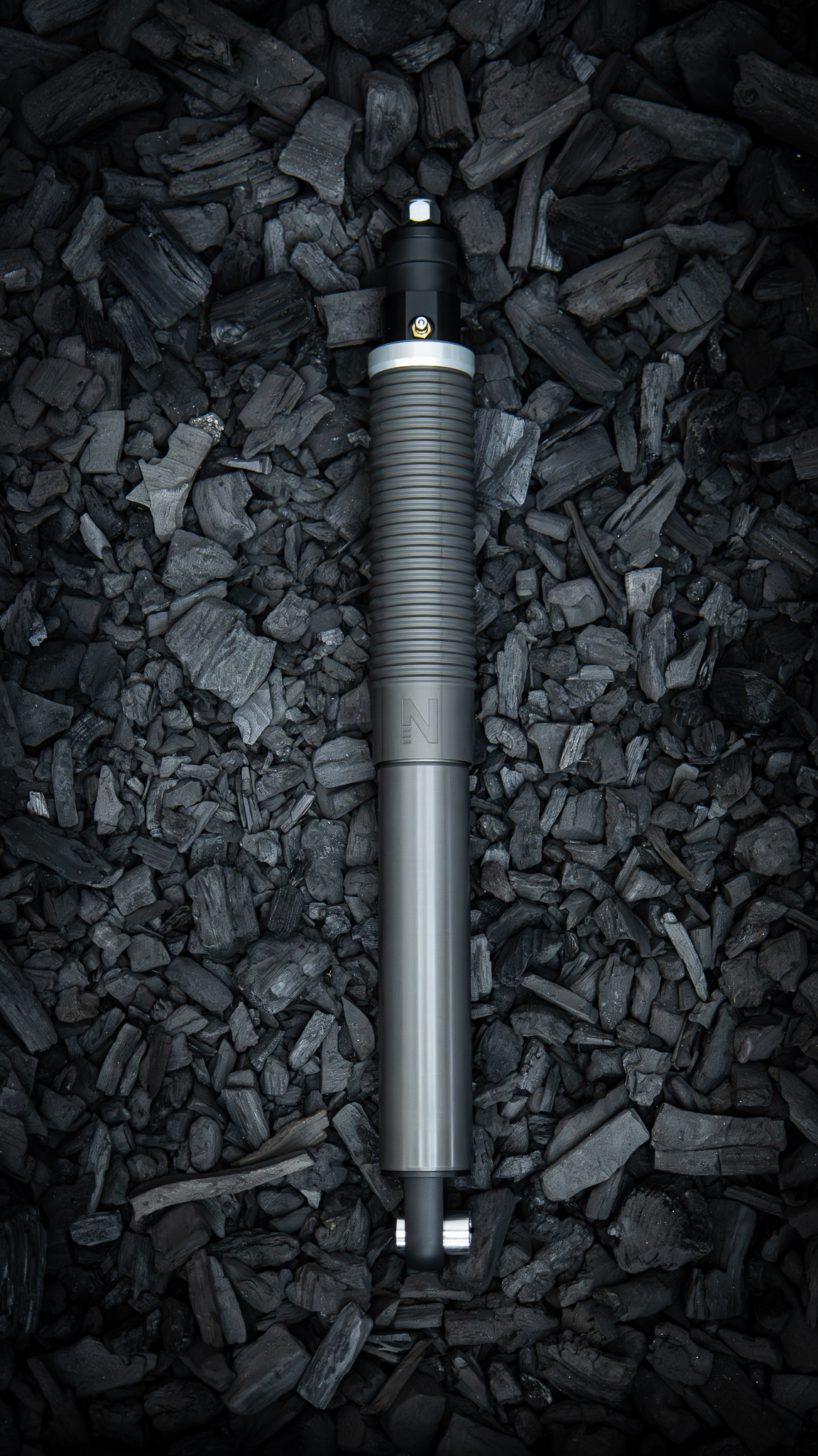 Nimbus Erebus oleo-pneumatic suspension unit, bronze and black sealed body on charcoal