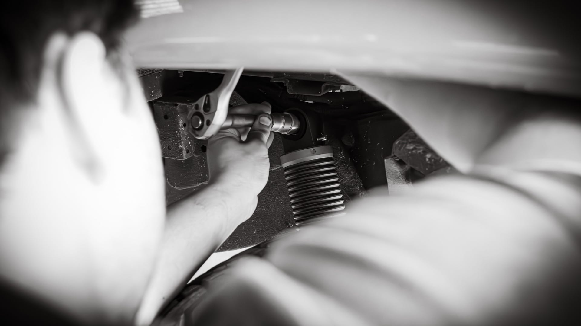 Technician installing a Nimbus suspension unit beneath a vehicle